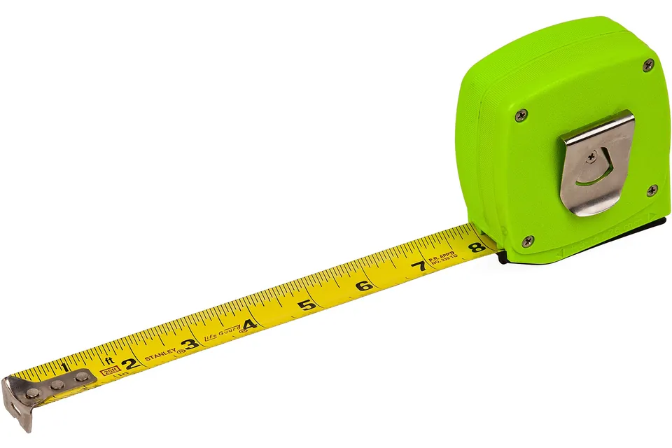 A green retractable tape measure partly extended across a white background